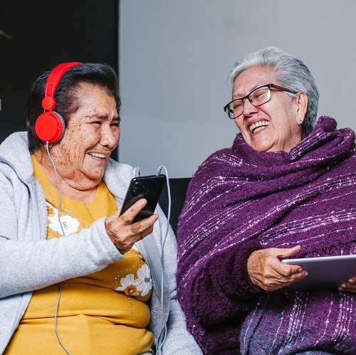 Latin Senior women listening music with headphones at home in Mexico city, mexican people